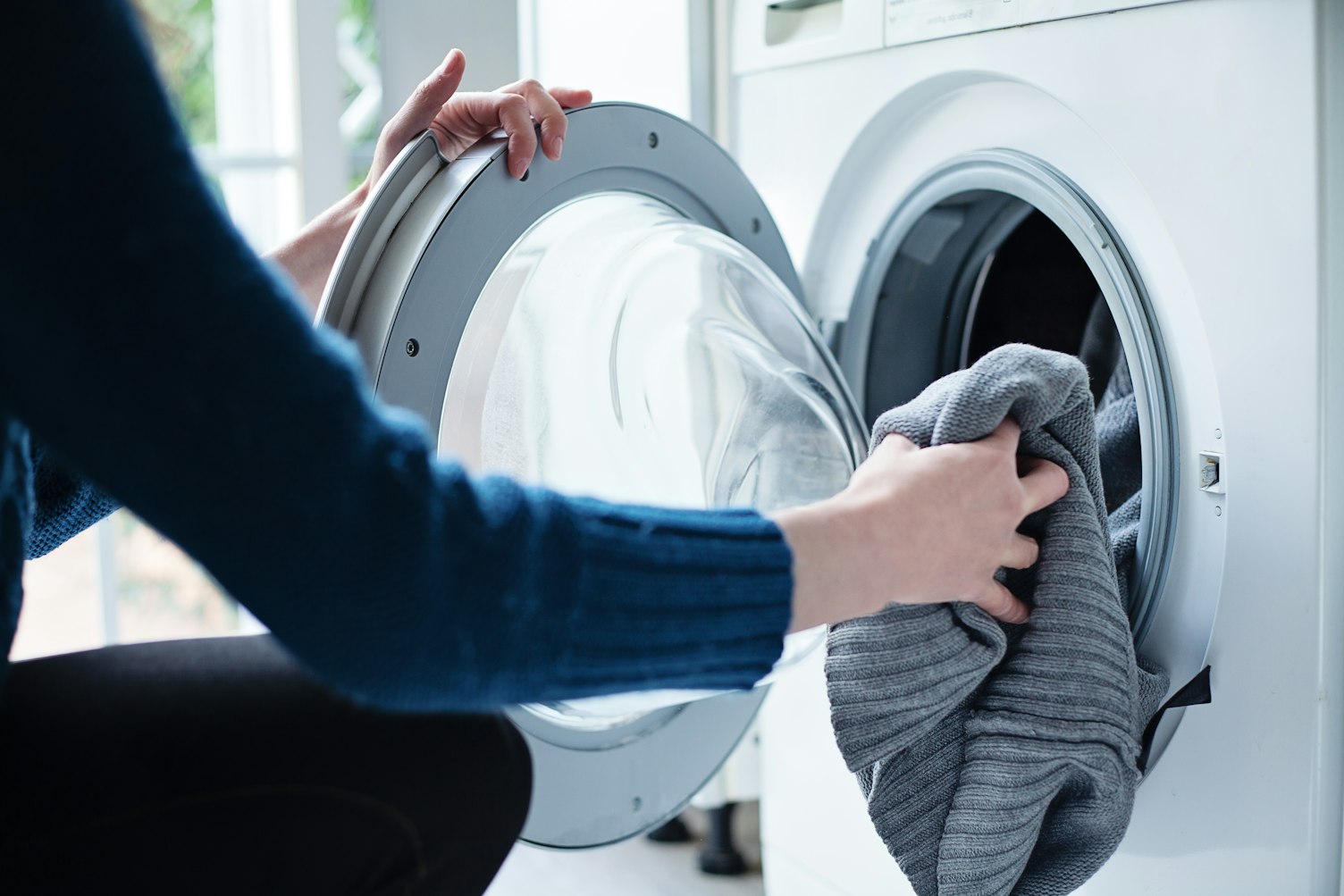 Woman Loading Dirty Laundry in Washing Machine NoFocalPoint