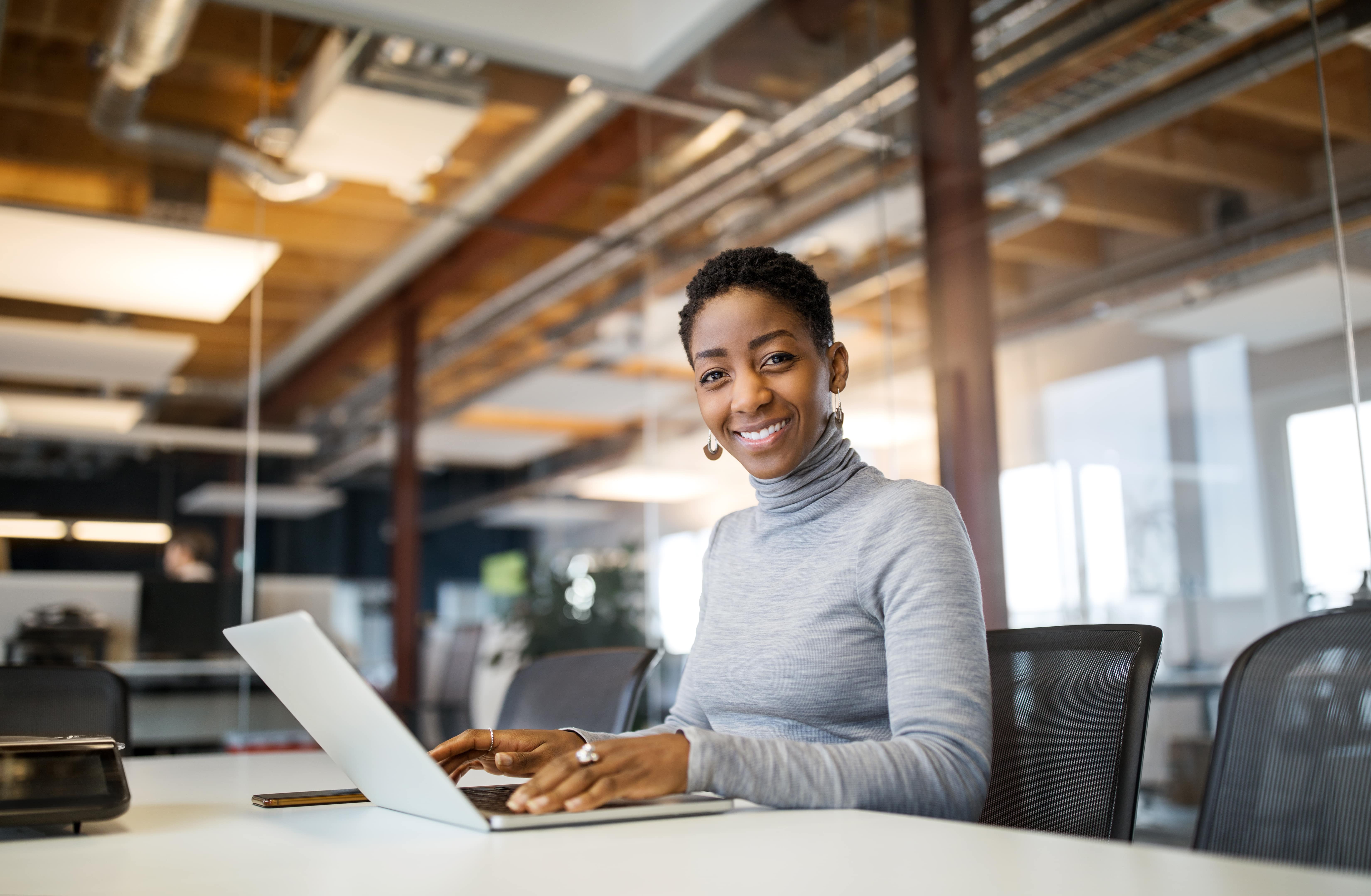 Woman Sitting in Conference Room Working on her Laptop