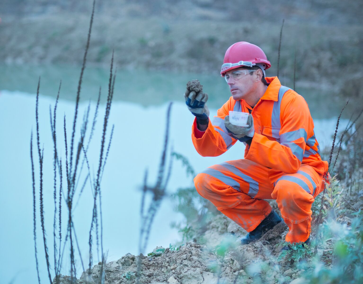 Worker Inspecting Soil in Quarry