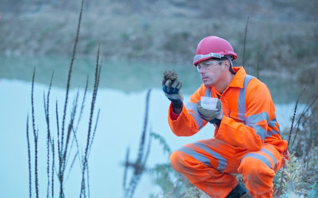 Worker Inspecting Soil in Quarry
