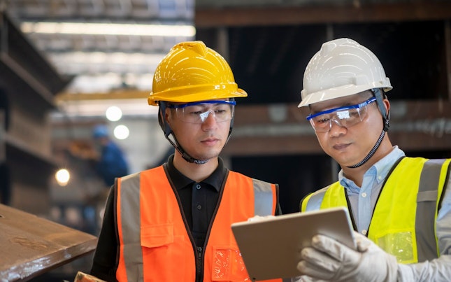Workers Using a Laptop in a Factory
