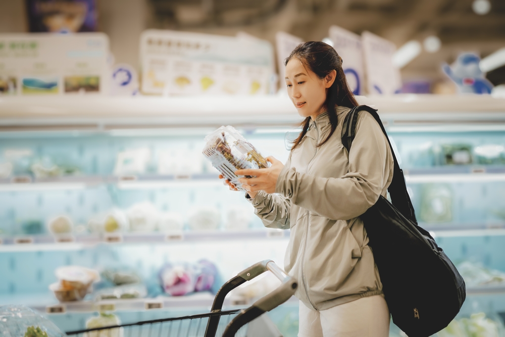 Young Woman Choosing Fresh Produce in a Supermarket Aisle