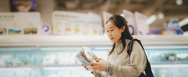Young Woman Choosing Fresh Produce in a Supermarket Aisle
