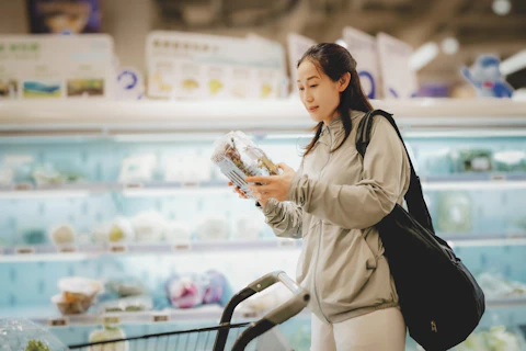 Young Woman Choosing Fresh Produce in a Supermarket Aisle