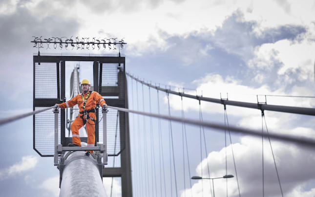 Trabajador de campo inspeccionando los tirantes de un puente