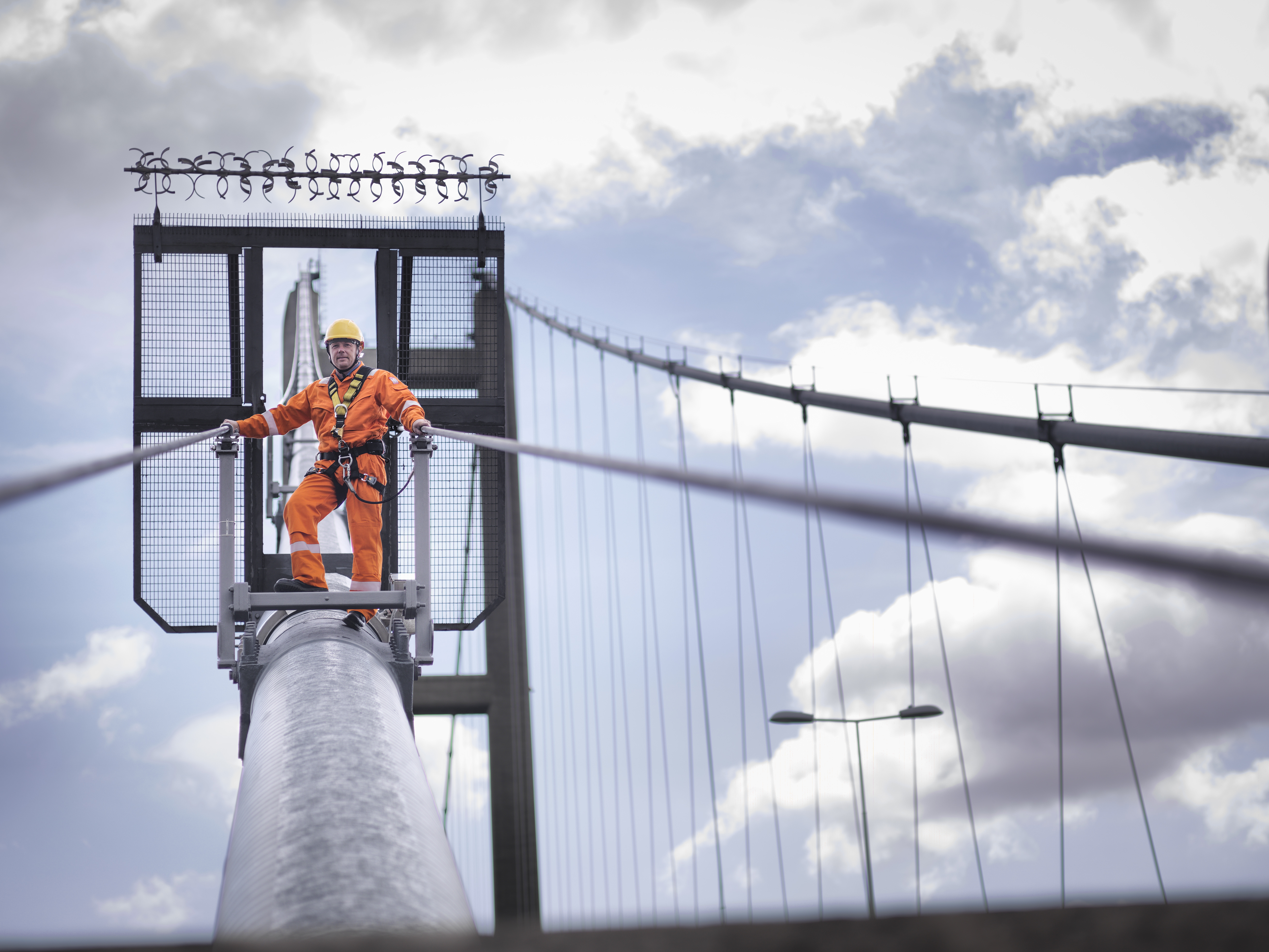 Trabajador de campo inspeccionando los tirantes de un puente