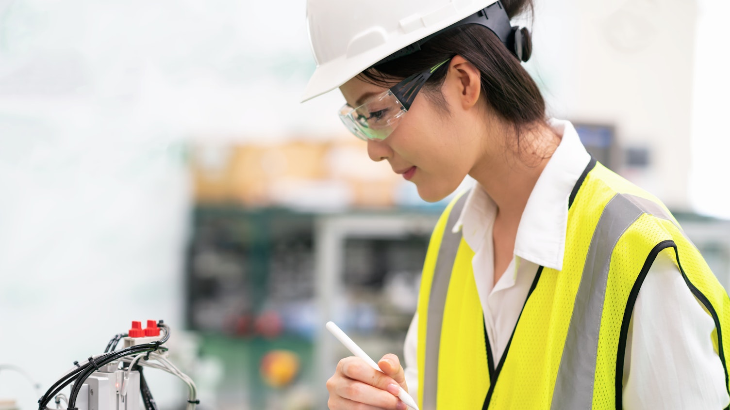 Woman Using Digital Tablet Controlling Machine in a Factory