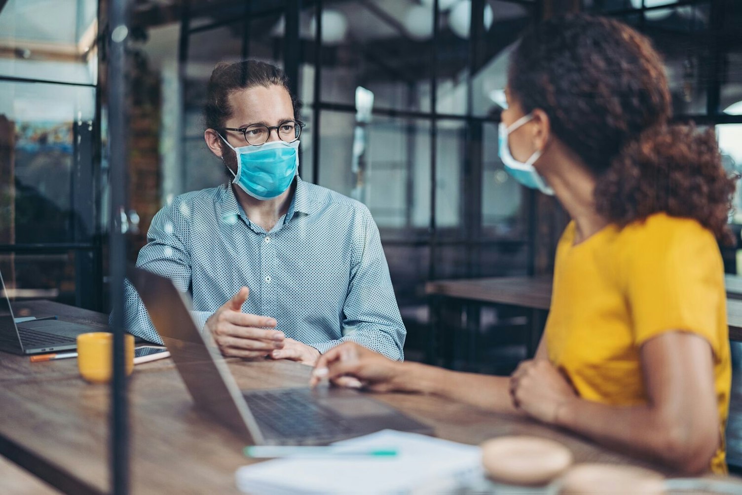 Geschäftskollegen mit Schutzmasken arbeiten im Besprechungsraum