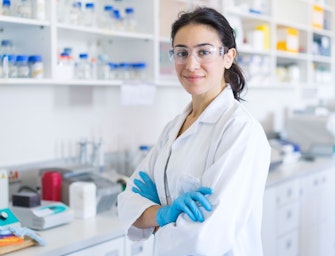 Scienziato in piedi a braccia conserte