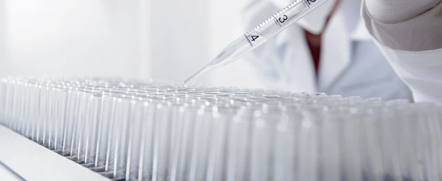 Scientist Dropping Liquid Into Test Tubes