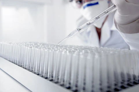 Scientist Dropping Liquid Into Test Tubes