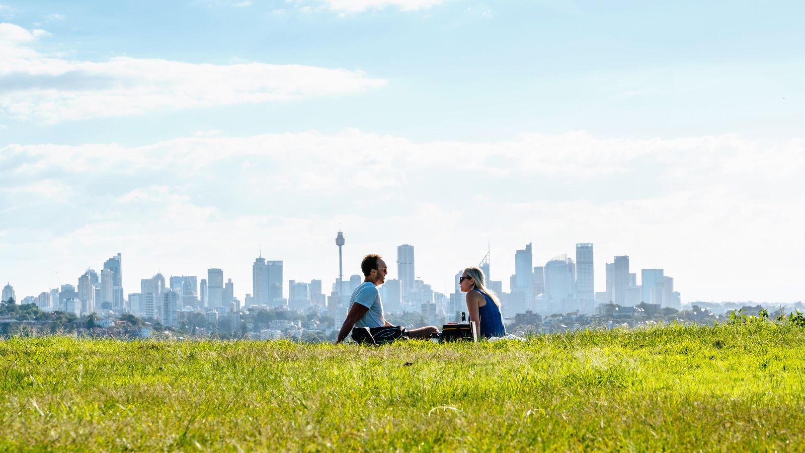 Couple Sitting in a Park with the City in the Background