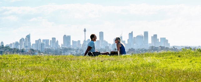 Couple Sitting in a Park with the City in the Background