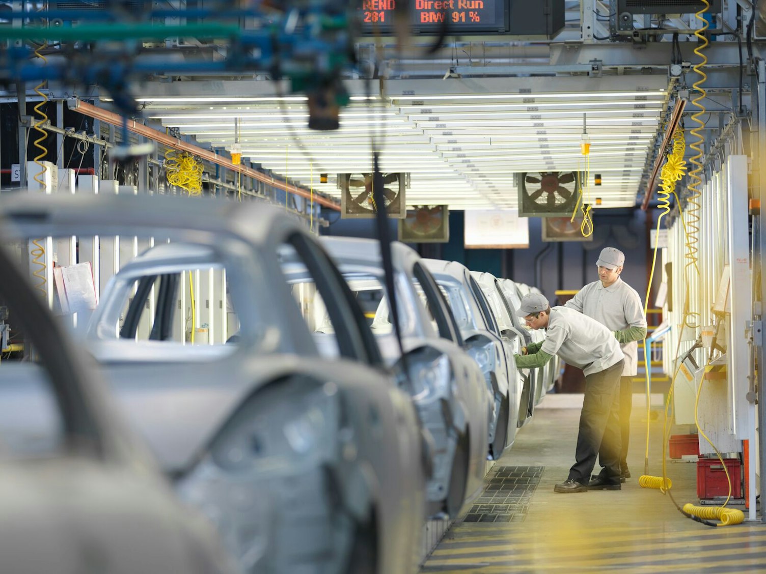 Pracownicy fabryki samochodów na linii produkcyjnej