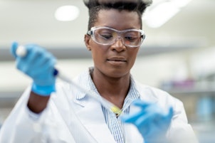 Scientist Using Pipette to Transfer Liquid Solution