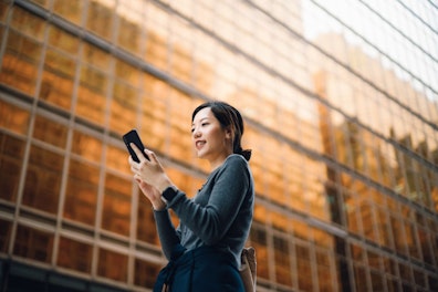 Businesswoman Using her Smartphone in the Street