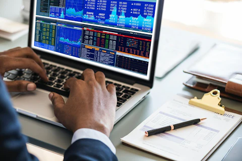 Man Working on a Computer Looking at Data and Graphs
