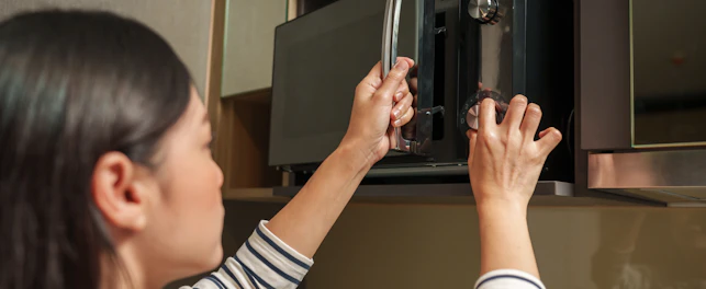 Woman Cooking with a Microwave in the Kitchen Room