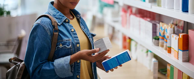 African American reading labels on skin care products while shopping in a pharmacy