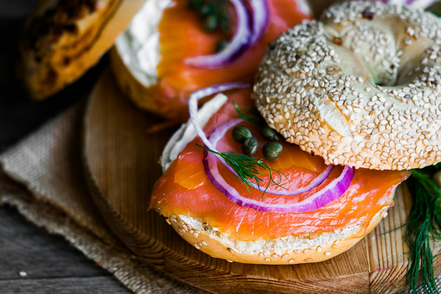 Bagels with cream cheese and smoked salmon on rustic wooden background