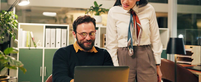 Business people and discussion with laptop in office for blog review working late and feedback Night
