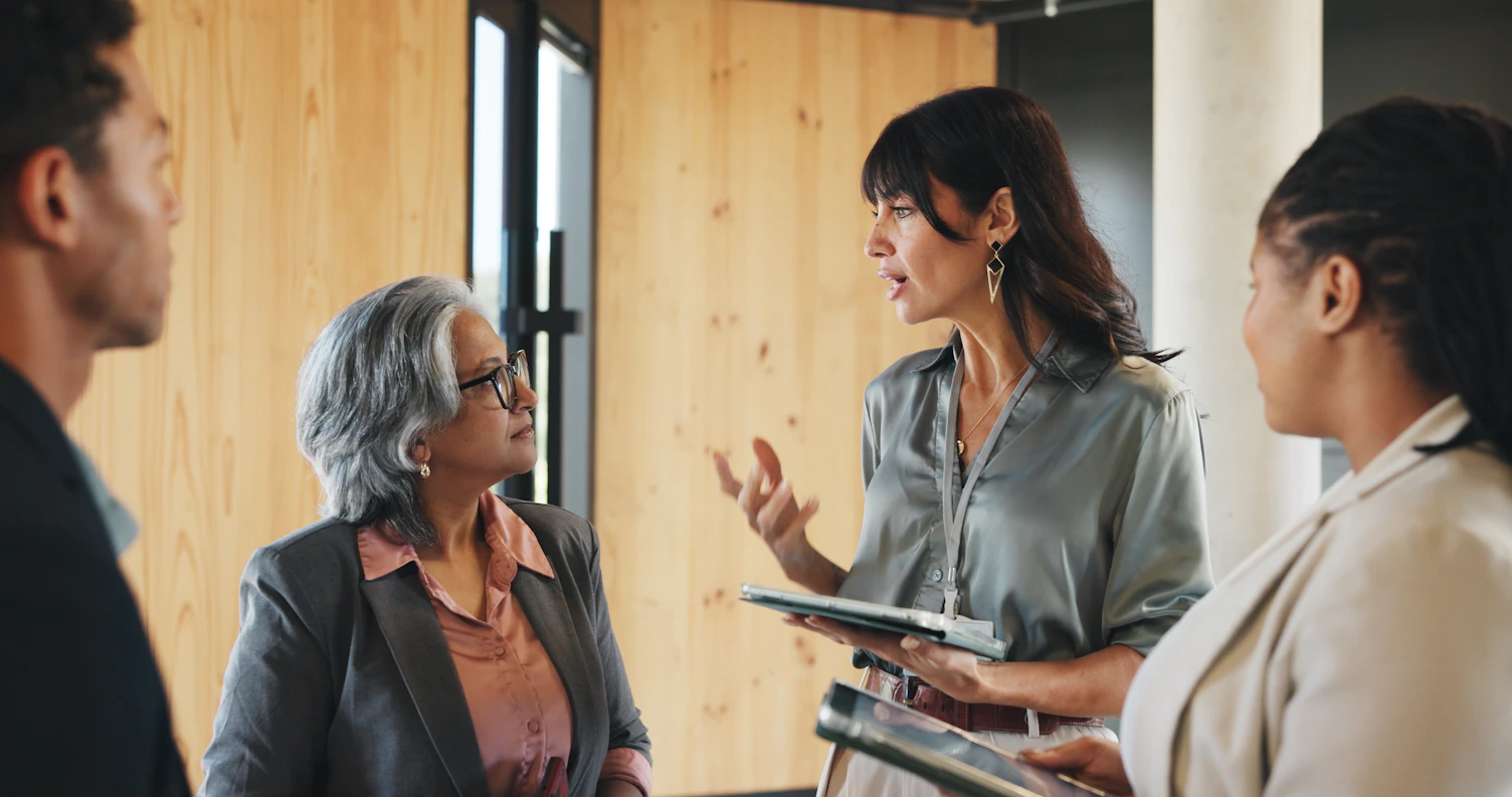 Business people talking and networking in workshop with tablet for expo advice and career developmen