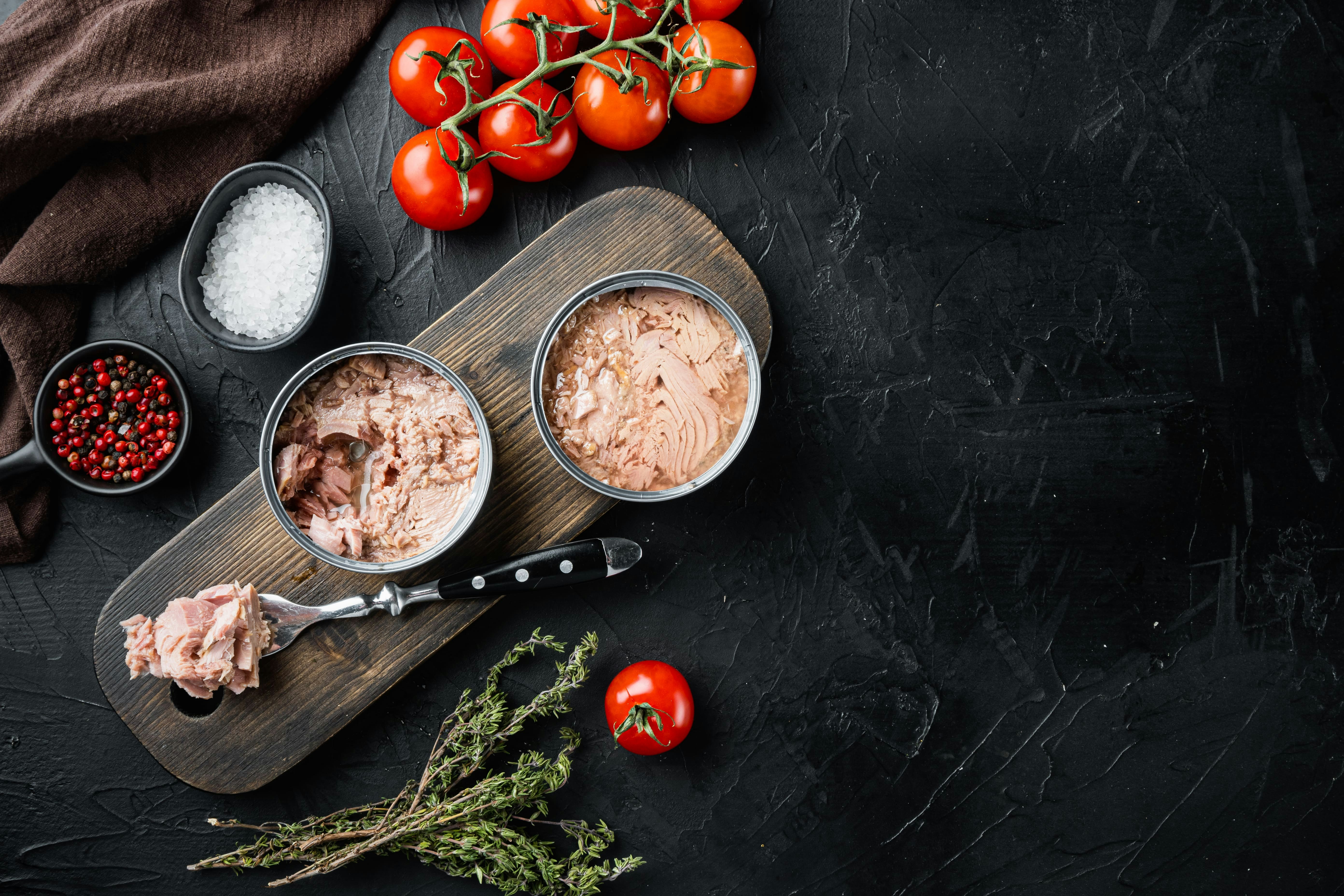 Canned italian tuna set on wooden cutting board