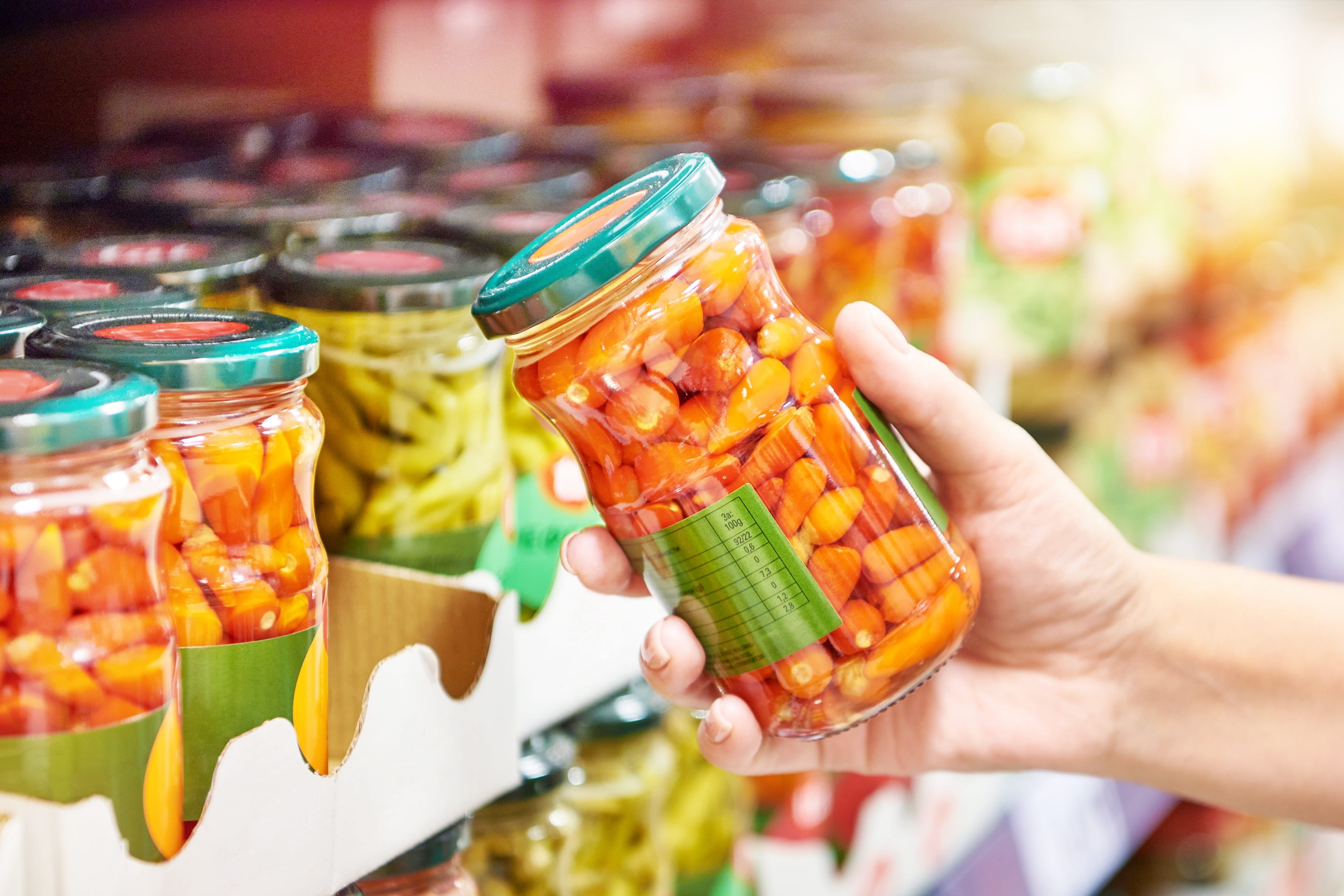 Canned red peppers vegetables in hands in store