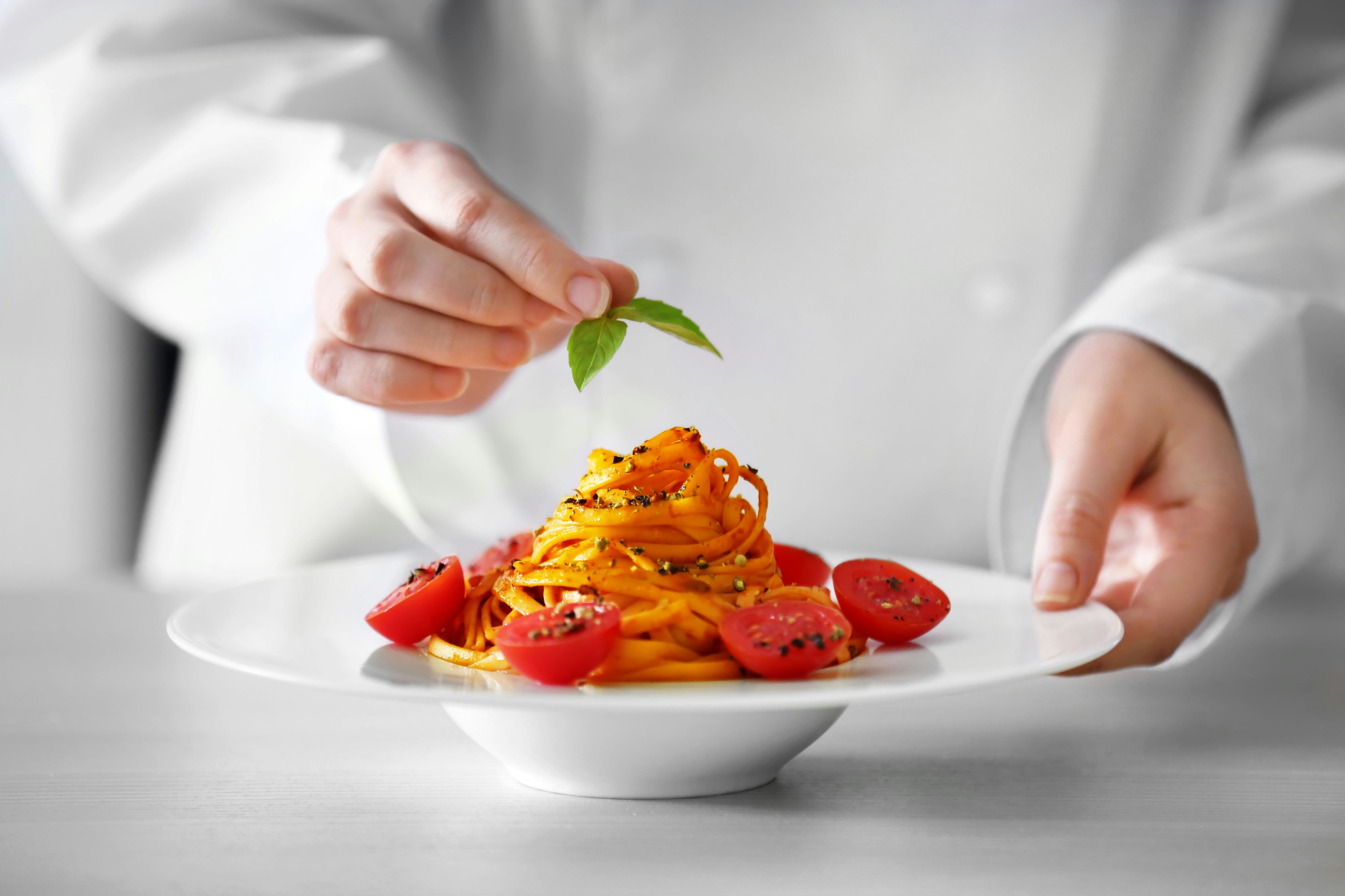 Chef Hands Preparing Delicious Cold Pasta Salad on the Table Closeup