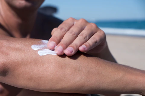 Closeup of a Man on the Beach Applying Sunscreen