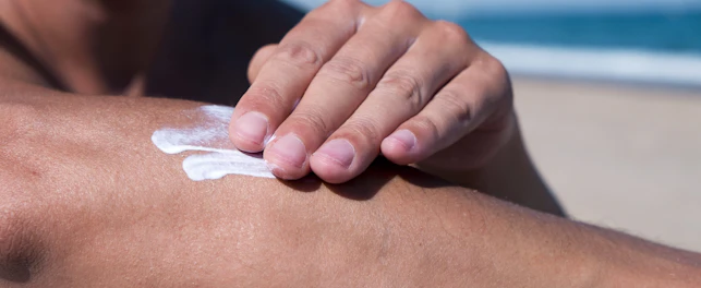 Closeup of a Man on the Beach Applying Sunscreen