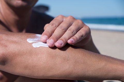 Closeup of a Man on the Beach Applying Sunscreen