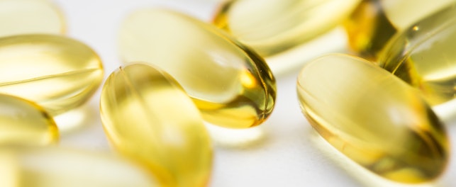 Closeup of clear yellow fish oil omega gel capsules