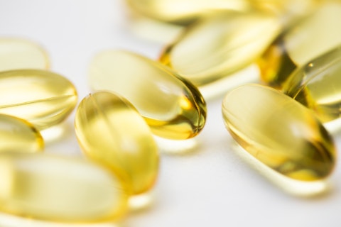 Closeup of clear yellow fish oil omega gel capsules