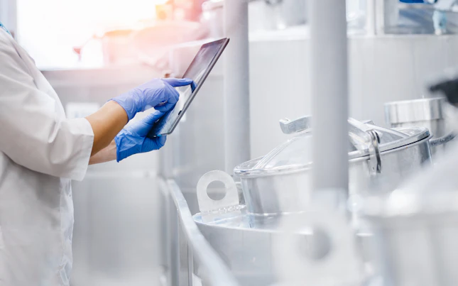 Banner de concepto de la industria alimentaria Trabajador de fábrica inspeccionando un camión cisterna de la línea de producción en una fábrica de lácteos wi