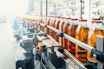 Conveyor belt juice in glass bottles on beverage plant or factory interior industrial manufacturing
