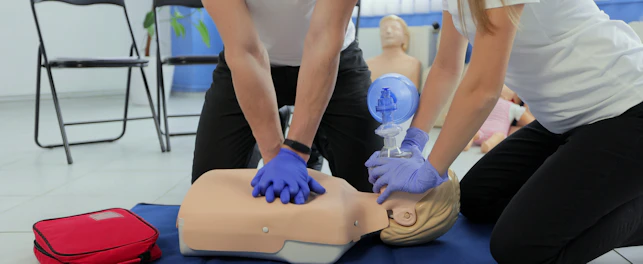 CPR classes students practicing in a dummy with rubber gloves
