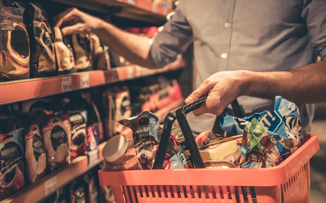 Cropped image of handsome man with a market basket doing shopping at the supermarket