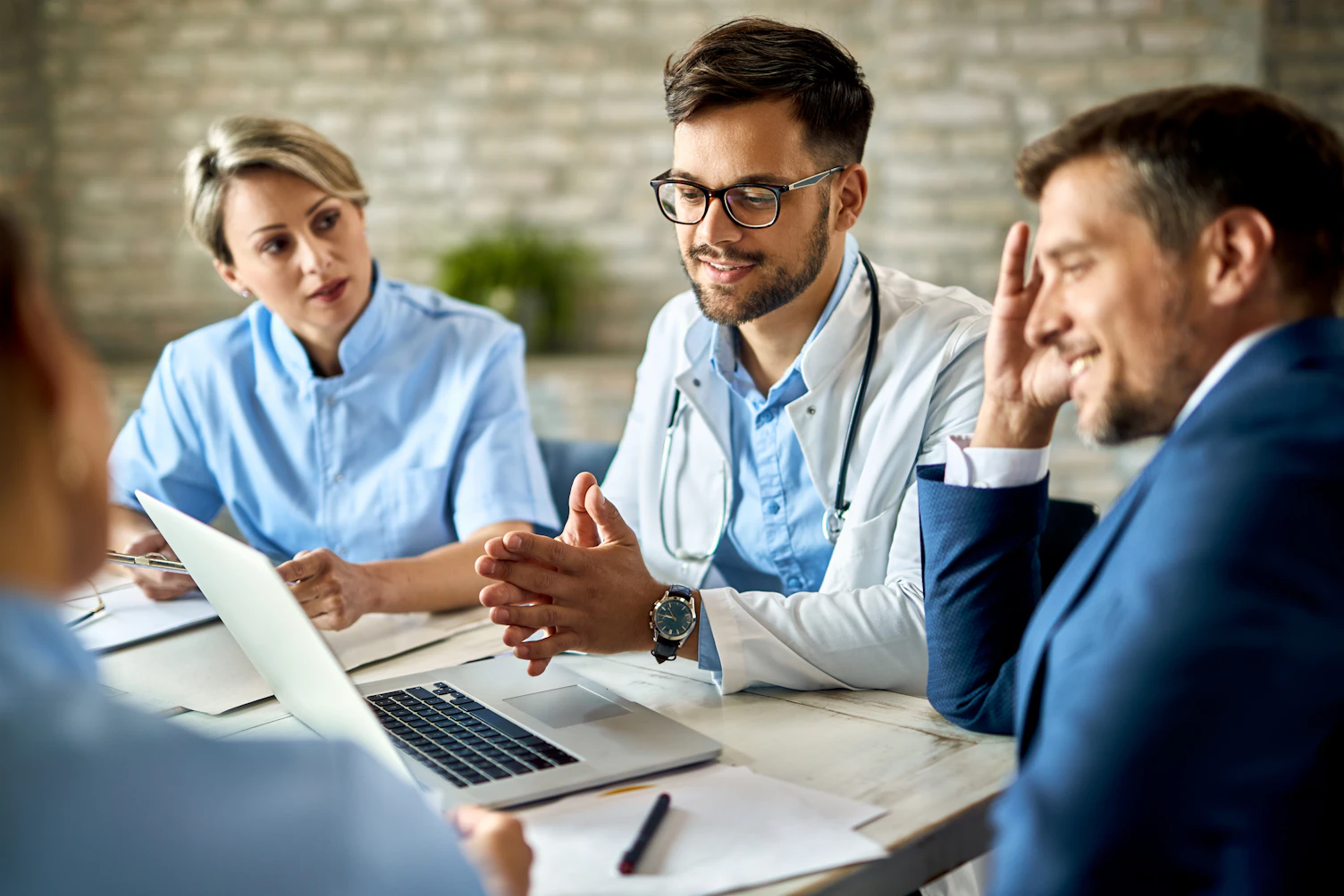 Group of healthcare workers and businessman using laptop while having a meeting in the office Focus