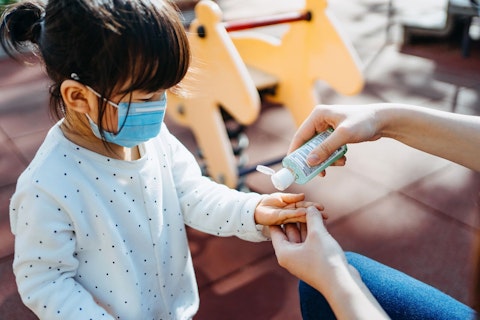 Little Girl Wearing Face Mask and Applying Hand Sanitiser 