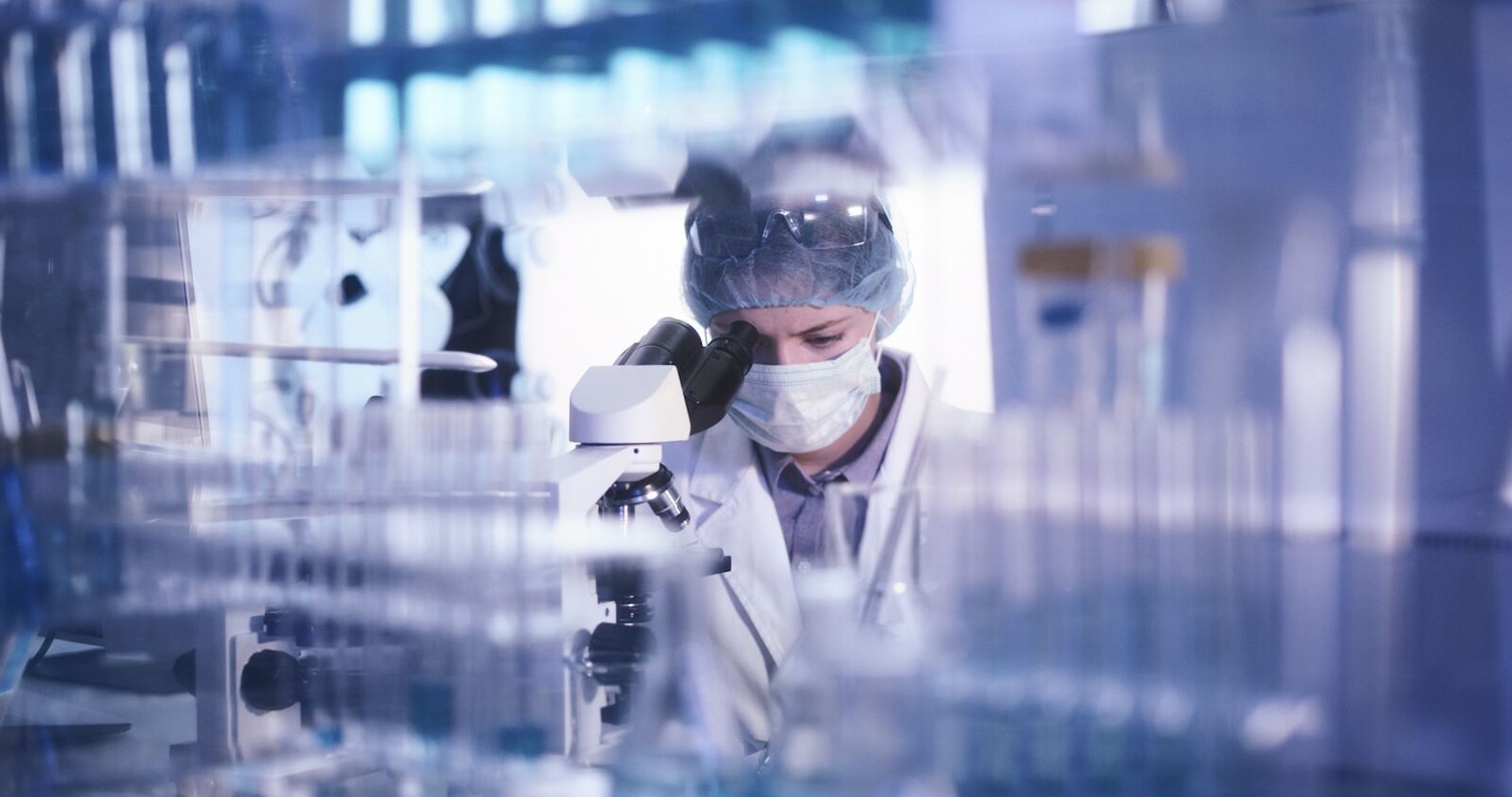 Microbiologist Studying Bacteria with Microscope