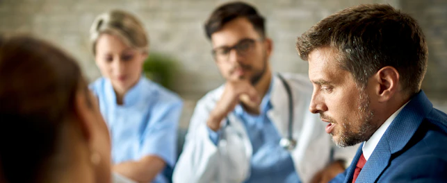 Mid adult businessman and healthcare workers analyzing documents during a meeting in the office