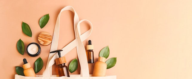 natural cosmetic products in a fabric bag surrounded by green leaves