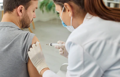 Nurse or Doctor Giving Injection in the Shoulder to Male Patient