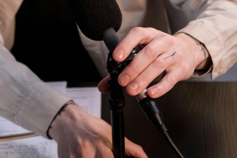 Photo of a Person's Hands Adjusting a Microphone