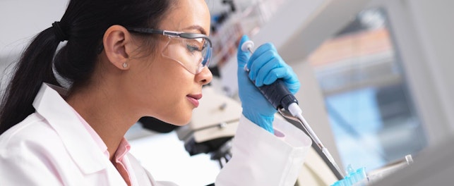 Tutkija pipetöi näytettä laboratoriossa