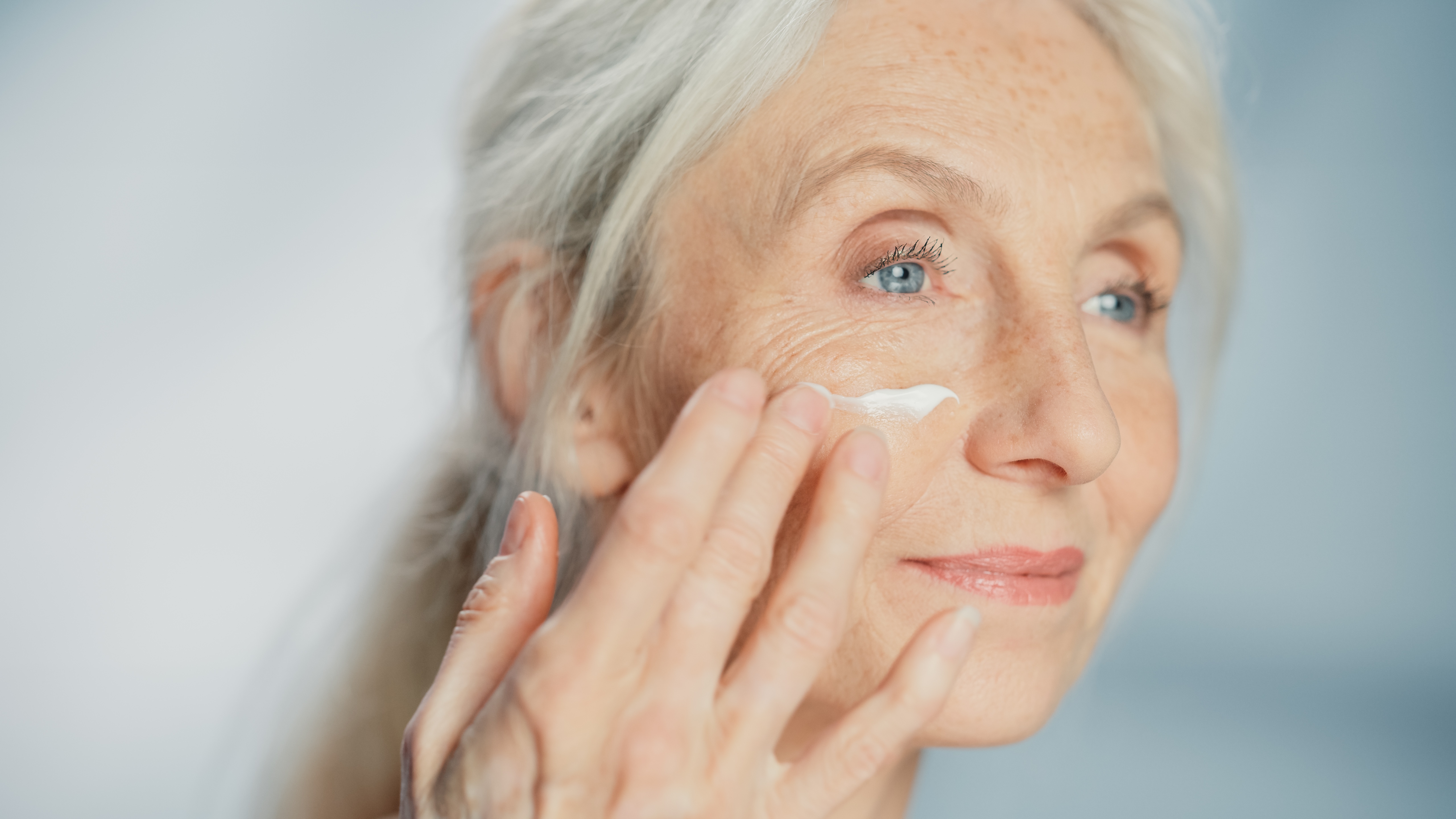 Senior Woman Gently Applying Face Cream
