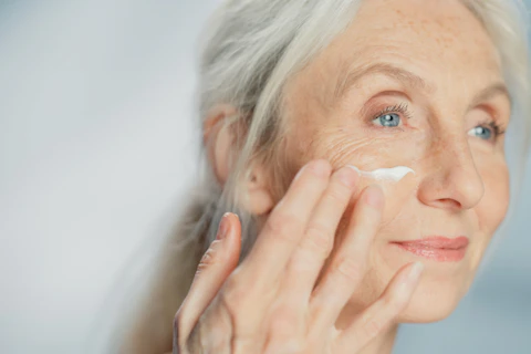 Senior Woman Gently Applying Face Cream