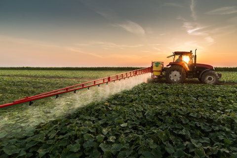 Tractor Spraying Pesticides on Vegetable Field with Sprayer at Spring