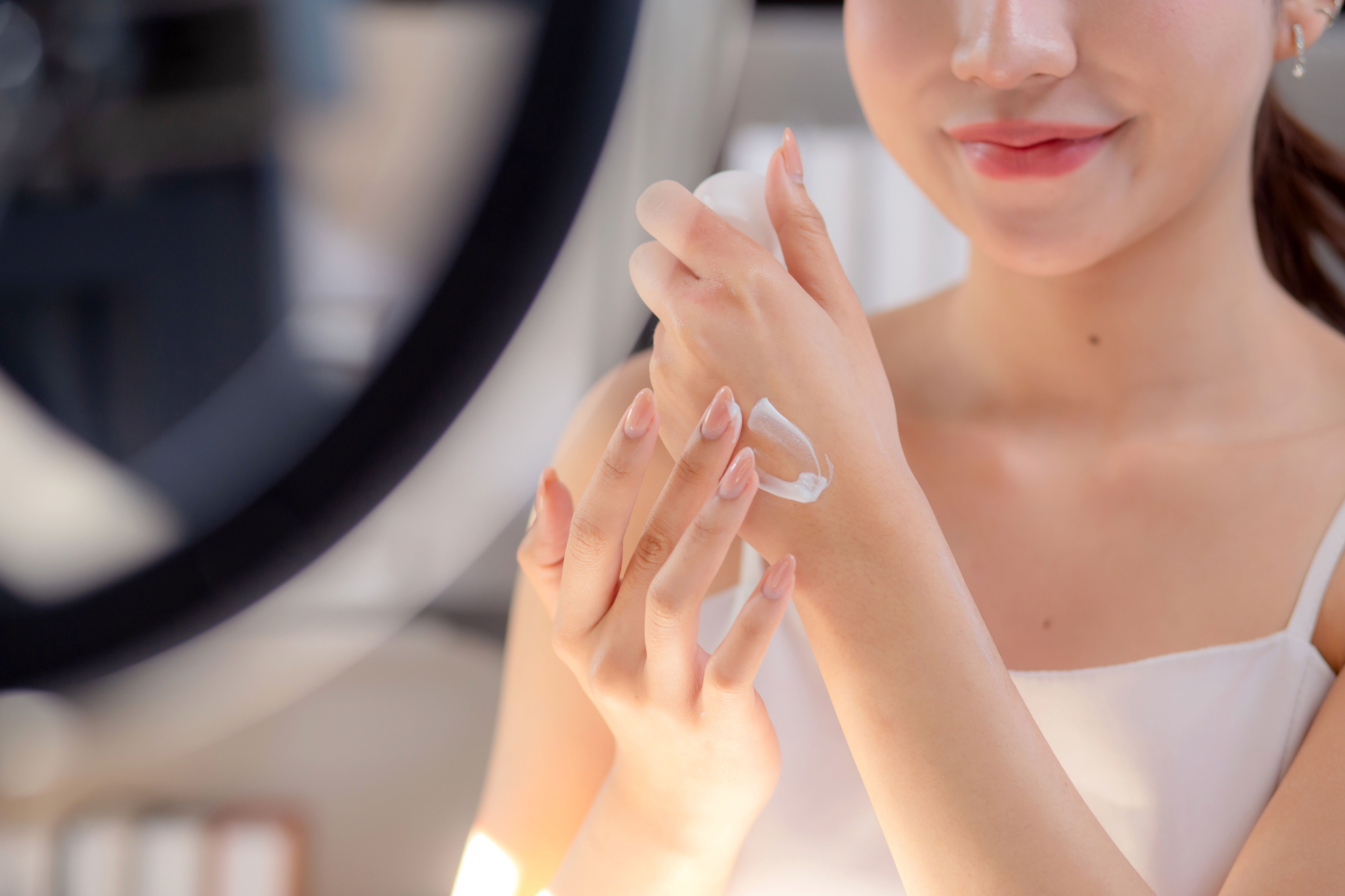 Woman applying a cosmetics cream to the back of her hand
